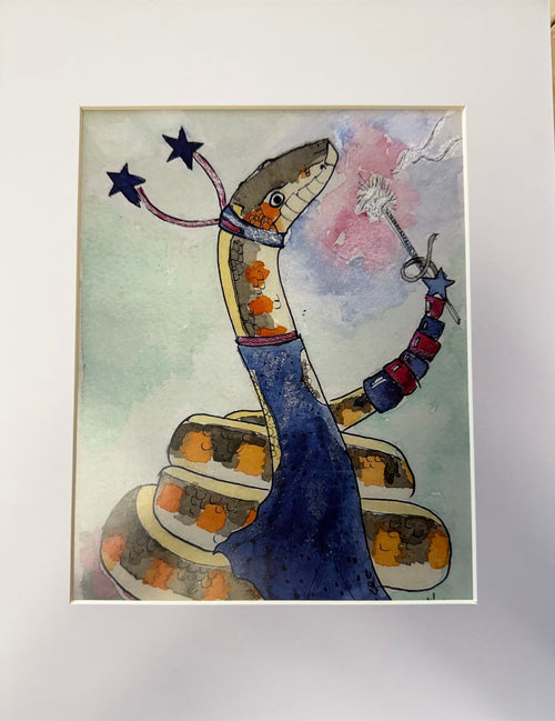 A whimsical watercolor shows a coiled snake standing upright in a long blue dress, its body patterned in browns, oranges, and cream. The snake wears a collar with two curved, star-tipped extensions and holds a wand with a dandelion-like puff and small star in its tail. The background is a soft pastel wash of green, pink, and blue, and the piece is set within a white mat.